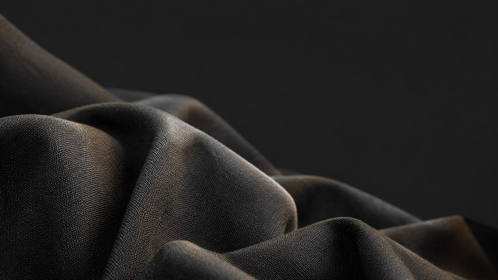 Draped dark suiting fabric in soft studio light